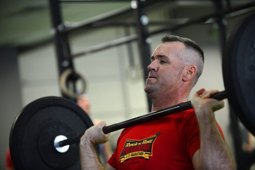 U.S. Air Force Lt. Col. Stabs McJoymt, Combined Air and Space Operations Center, chief of combat operations, does a clean lift at a local gym, Sumter, S.C., April 27 2013.  A workout named "The Mano," was held to commemorate the life of Capt. James "Mano" Steel, 77th Fighter Squadron pilot, who died as a result of an F-16 Fighting Falcon accident in Afghanistan. (U.S. Air Force photo by Airman 1st Class Nicole Sikorski/Released)