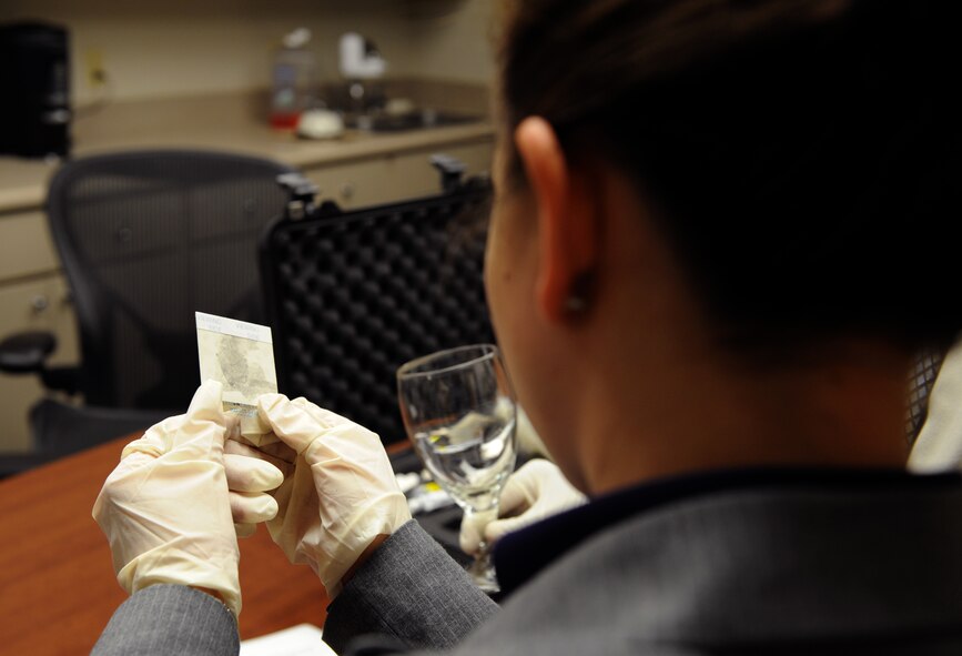 Special Agent Amber Padgett, Air Force Office of Special Investigations Detachment 812, inspects an extracted finger print on Barksdale Air Force Base, La., April 29, 2013. The OSI office handles on-base and off-base incidents which involve military members or present a threat to Barksdale and the Air Force. (U.S. Air Force photo/Airman 1st Class Benjamin Gonsier)