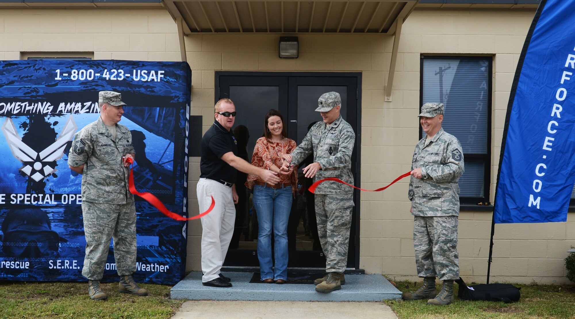 U.S. Air Force Senior Master Sgt. Ken Adamczyk, 337th Recruiting Squadron superintendent, and Master Sgt. Robert Workman, 337th RS first sergeant, hold a ribbon while Sean Loughrey, 337th RS building custodian, April Burnette, 20th Civil Engineer Squadron real property officer, and Lt. Col. Troy Kimball, 337th RS commander, cut the ribbon in front of the new recruiting squadron building, Shaw Air Force Base, S.C., April 26, 2013. The 337th RS moved about a month ago from the 20th Mission Support Group building into Building 1832. This was the first day the recruiting squadron put the building to use. (U.S. Air Force photo by Senior Airman Tabatha Zarrella/Released)
