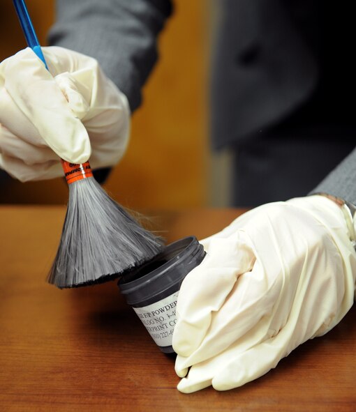 Special Agent Amber Padgett, Air Force Office of Special Investigations Detachment 812, applies finger print dust on a brush on Barksdale Air Force Base, La., April 29, 2013. Dusting for finger prints involves dusting with fine particles of the powder to adhere to residue left by skin from palms, fingers and feet. (U.S. Air Force photo/Airman 1st Class Benjamin Gonsier)