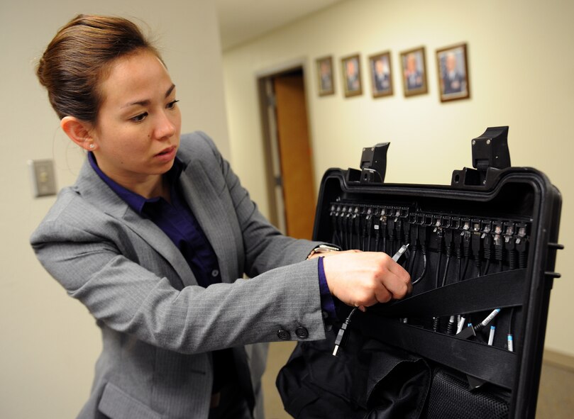 Special Agent Amber Padgett, Air Force Office of Special Investigations Detachment 812, searches for a phone cord on Barksdale Air Force Base, La., April 29, 2013. Before extracting data from a cell phone for an investigation, Padgett ensured she had the right cord for the phone. (U.S. Air Force photo/Airman 1st Class Benjamin Gonsier) 