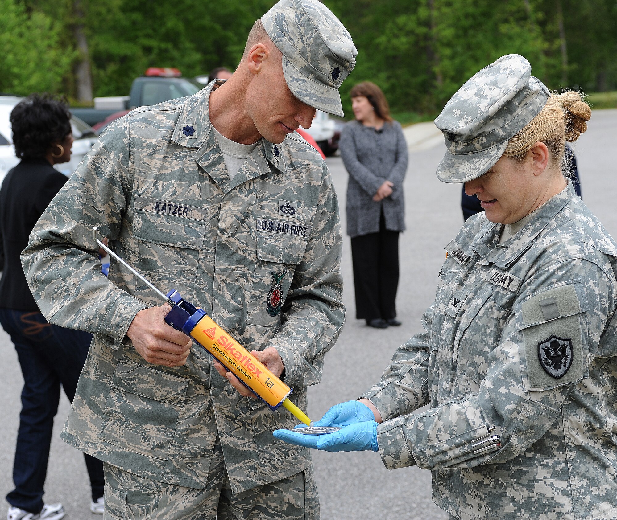 U.S. Air Force Lt. Col. Dee Jay Katzer, 633rd Civil Engineer Squadron commander and U.S. Army Col. Jayne V. Jansen, 633rd Air Base Wing vice commander, work together to install medallions over storm drains in Bethel Manor’s Jamestown Village, Va., April 24, 2013. Volunteers spent the morning installing the medallions for Earth Week to remind residents to keep the storm drains clean. (U.S. Air Force photo by Senior Airman Teresa Aber/Released)