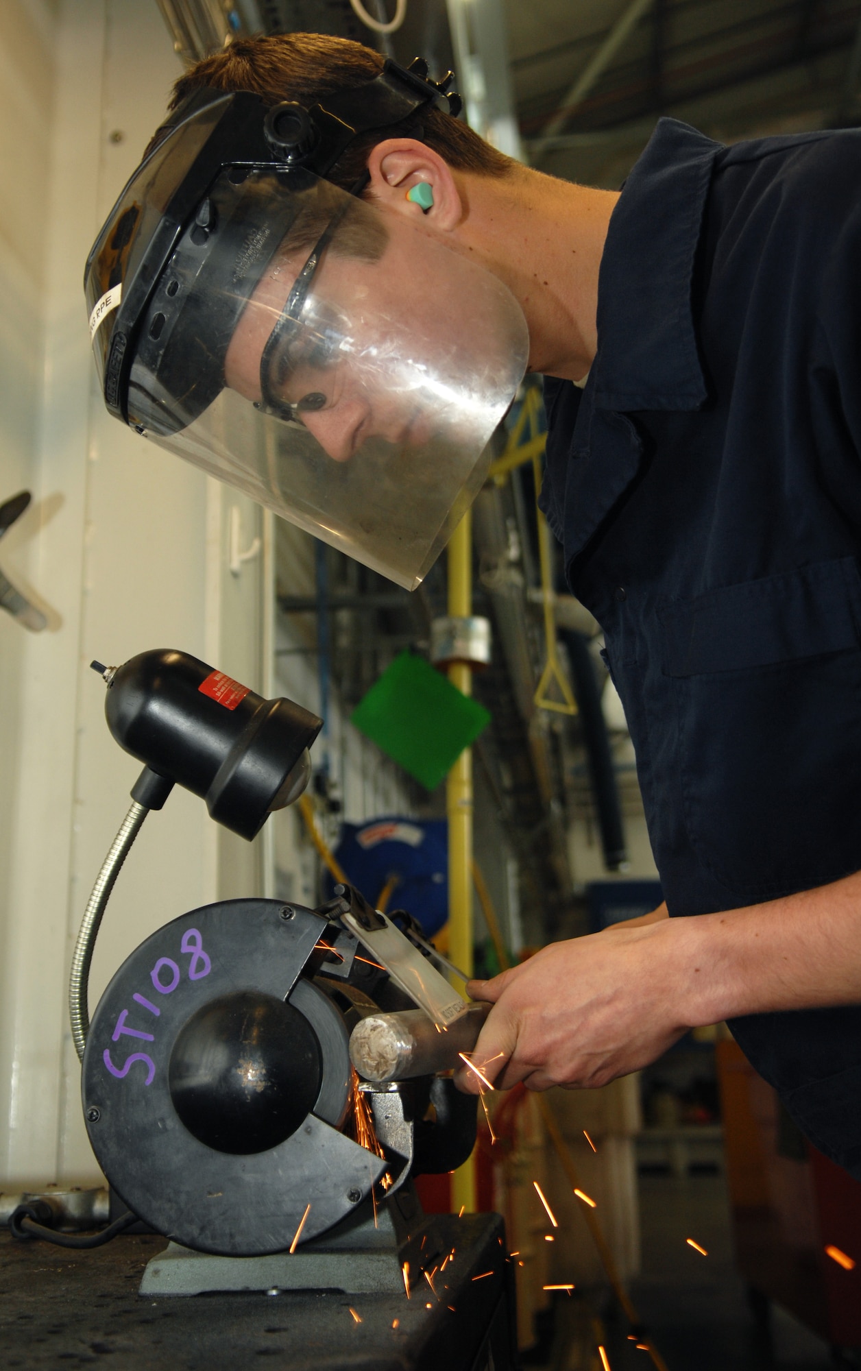 Airman 1st Class Kiley Greathouse, 100th Logistics Readiness Squadron Vehicle Management apprentice, grinds down the edge of a metal punch April 26, 2013, on RAF Mildenhall, England. (U.S. Air Fprce photo by Airman 1st Class Dillon Johnston/Released)