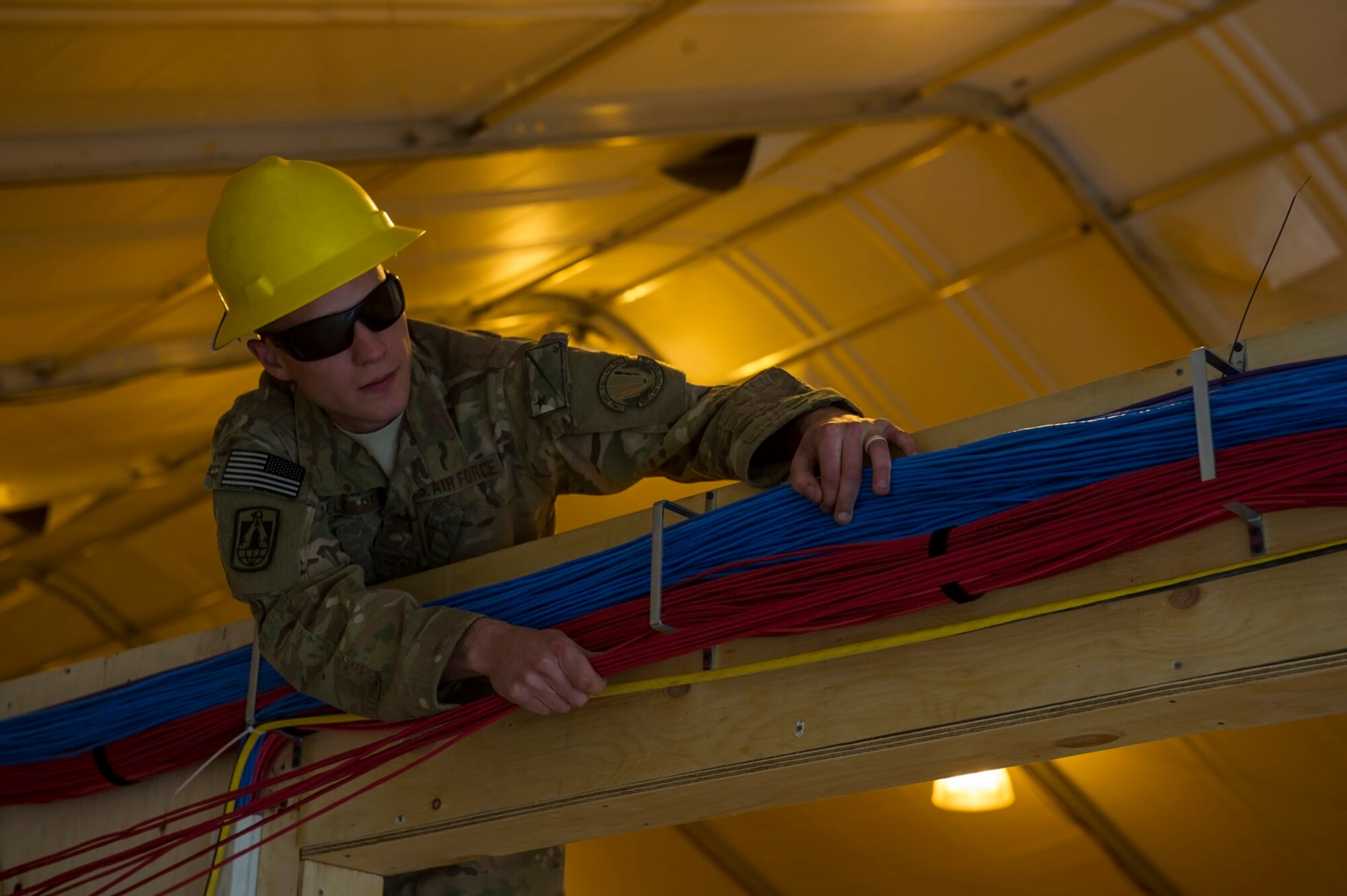U.S. Air Force Staff Sgt. Andrew Mielcarek, 160th Theater Signal Support Brigade cable and antenna systems craftsman, runs telephone and computer cable in a Joint Operations Center, March 19, 2013, at Bagram Airfield, Afghanistan. Mielcarek is a member of an Air National Guard Engineering & Installation Team deployed from the 219th Engineering Installation Squadron, Tulsa, Oklahoma.  Mielcarek is a native of Tulsa, Oklahoma. (U.S. Air Force photo by Staff Sgt. Marleah Miller)