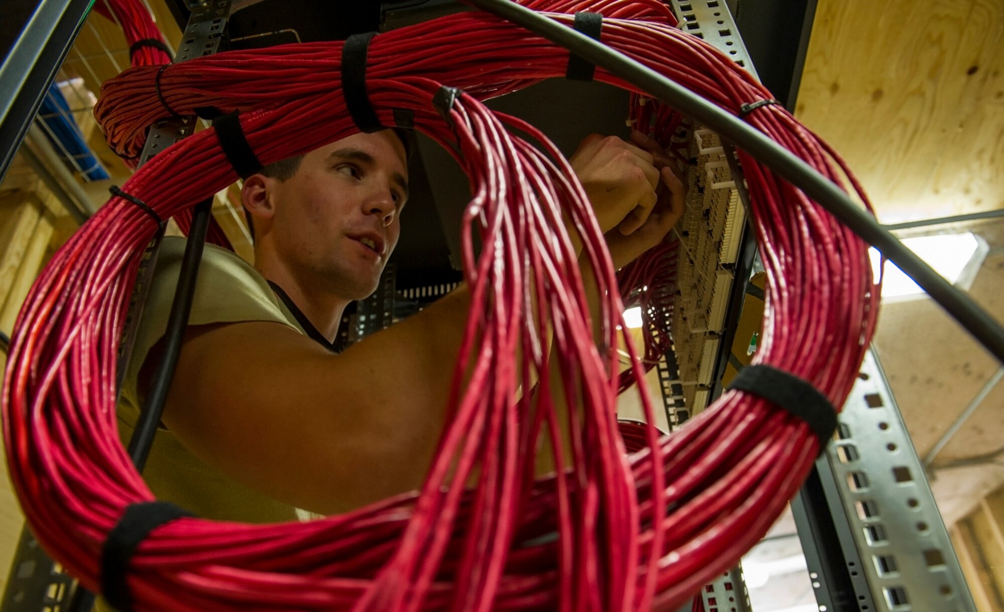 U.S. Air Force Senior Airman Derrick Rudkins, 160th Theater Signal Support Brigade cyber transport specialist apprentice, routes cables to a patch panel March 19, 2013, at Bagram Airfield, Afghanistan. Rudkins is a member of an Air National Guard Engineering & Installation Team deployed from the 205th Engineering Installation Squadron, Oklahoma City, Oklahoma. Rudkins is a native of Mustang, Oklahoma. (U.S. Air Force photo by Staff Sgt. Marleah Miller)