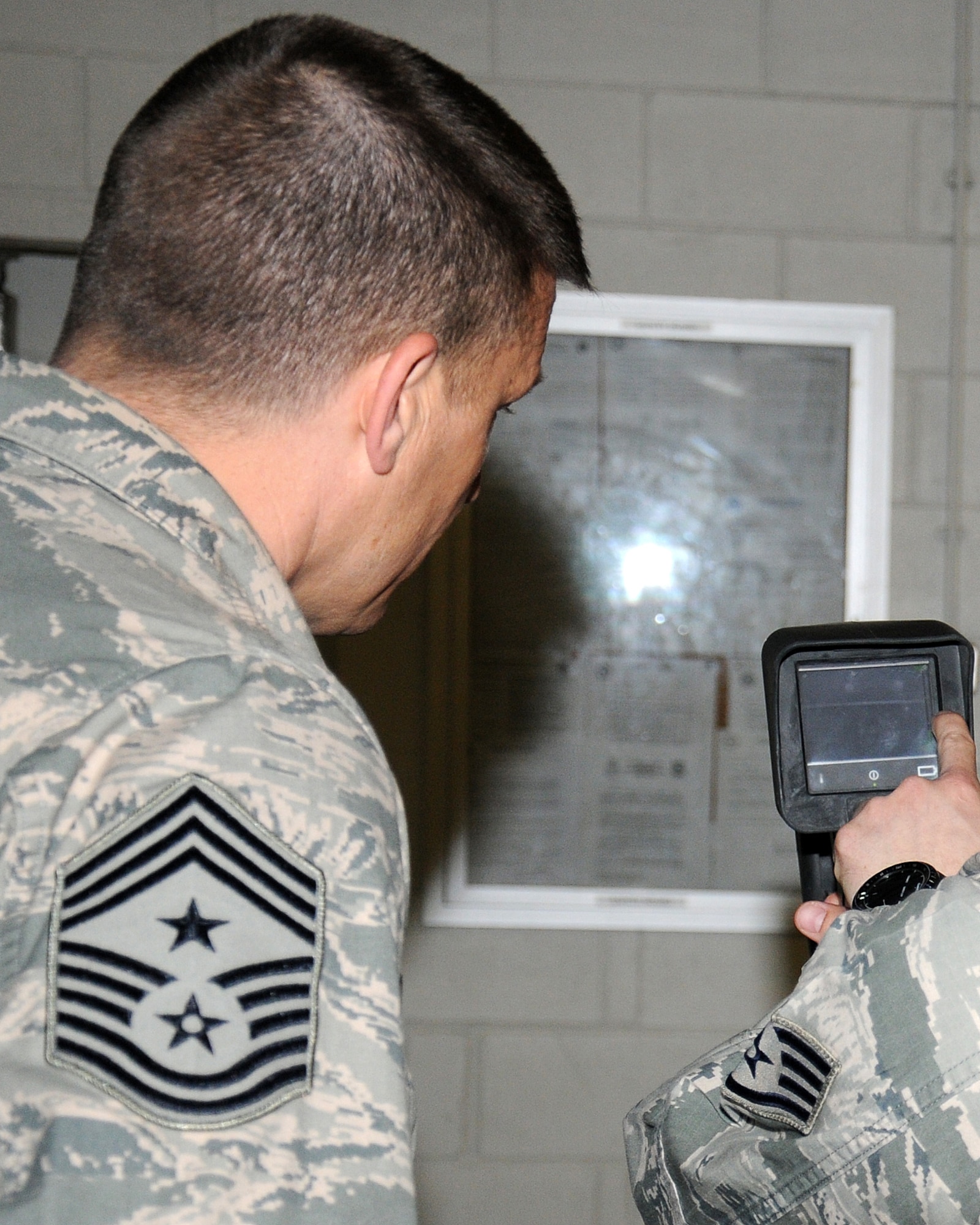 From right, Staff Sgt. Noah Leiter, 100th Civil Engineer Squadron Fire Department firefighter from Carthage, Mo., shows Chief Master Sgt. Tracy Jones, 100th Air Refueling Wing command chief how to use a thermal imagery camera that displays heat sources inside a structure up to 3,000 degrees Fahrenheit, April 25, 2013, at RAF Mildenhall, England. The fire department personnel showed Jones how they do their job as part of a “dirty jobs” initiative. Thermal imagery cameras are used so crew members can rapidly identify if anyone is inside a burning building. (U.S. Air Force photo by Gina Randall/Released)