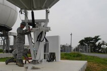 U.S. Air Force Senior Airmen Nathaniel Lee and William Amarillo, 18th Communications Squadron radio frequency transmissions technicians, check and treat for corrosion on the weather-exposed meteorological weather antenna on Kadena Air Base, Japan,  April 24, 2013. The Mark4B system is the primary source used for satellite imagery by U.S. Air Force forecasters. (U.S. Air Force photo by Staff Sgt. Lauren Snyder/Released)