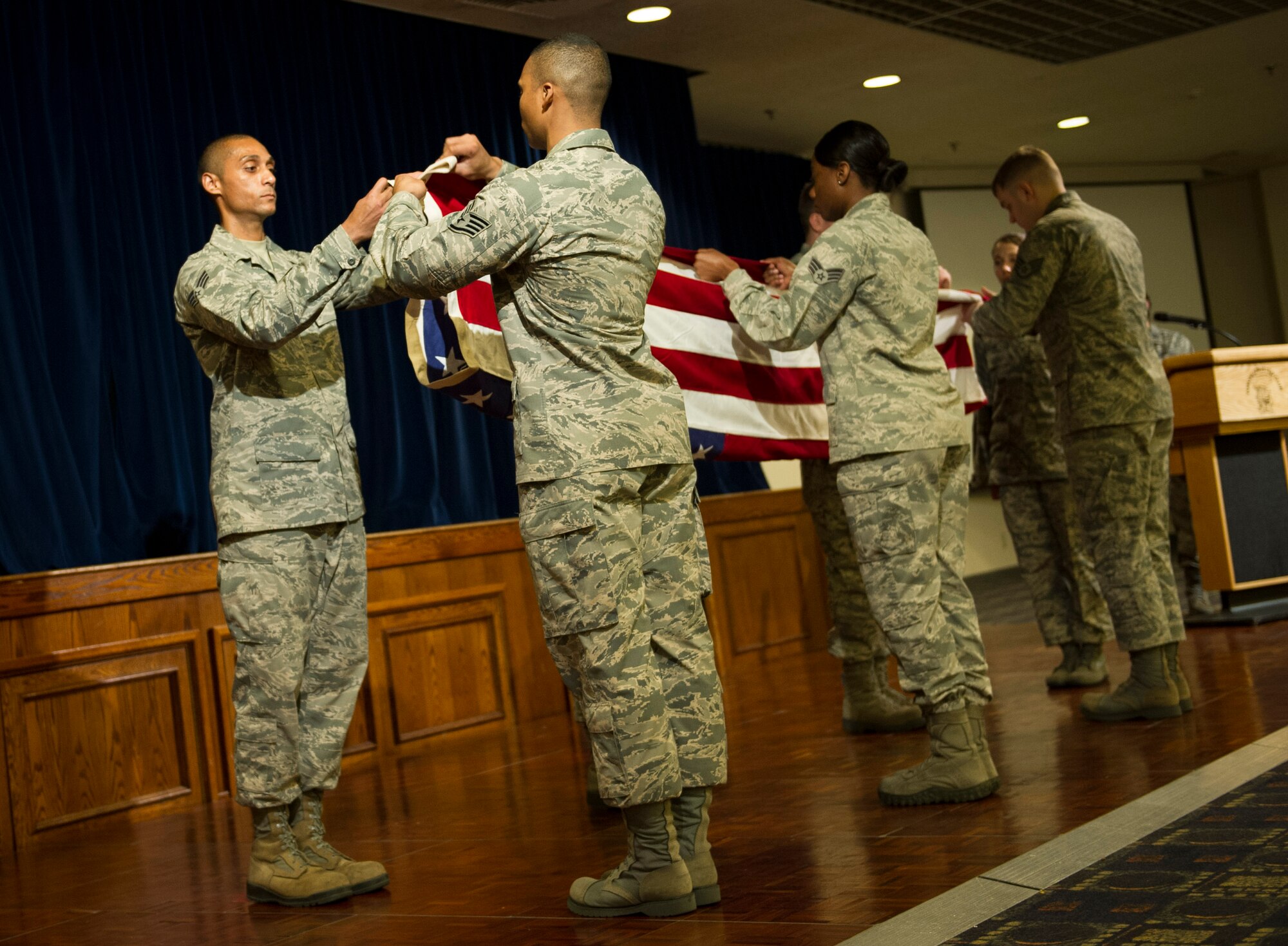 YOKOTA AIR BASE, Japan -- Yokota's honor guard members demonstrate a six-man flag fold during the 2013 Honor Guard Recognition Banquet at Yokota Air Base, Japan, April 26, 2013. By displaying the flag and giving it a distinctive fold, honor guardsmen show respect to the flag and express their gratitude to those individuals who fought, and continue to fight for freedom, at home and abroad. (U.S. Air Force photo by Senior Airman Andrea Salazar/Released)