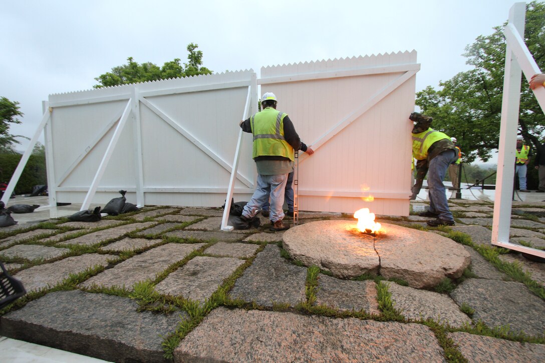 Contractors install white fencing  at the John F. Kennedy Eternal Flame at Arlington National Cemetery April 29, 2013. The fencing will block the public’s view of the flame while contractors install burners, an igniter and new gas and air lines. Work on the burner itself will take about three weeks to complete. (U.S. Army photo/Patrick Bloodgood)