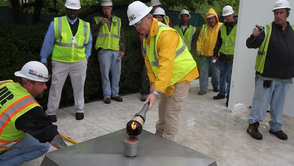 ARLINGTON, Va. – Randy Barton, an Arlington National Cemetery engineering technician, lights a temporary flame using a torch that was lit from the John F. Kennedy Eternal Flame at the cemetery April 29, 2013. The temporary flame will burn while the permanent flame undergoes repair and upgrade work to install new burners, a new igniter and new gas and air lines. Work on the burner itself will take about three weeks to complete. (U.S. Army photo/Patrick Bloodgood)