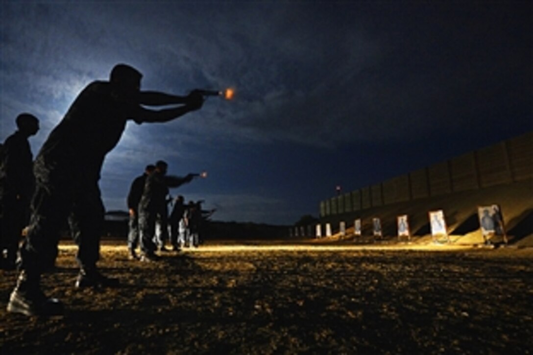 Navy Petty Officer 2nd Class Steven Mitchell shoots an M9 pistol during a visit, board, search and seizure basic small-arms qualification on the USS Pickney in Port Hueneme, Calif., April 24, 2013. The Pinckney is at Port Hueneme conducting a combat systems and deck groom preparing for an upcoming board of inspection and survey. It is conducted every five years of a ship's life to ensure mission readiness and material conditions are up to standards. 