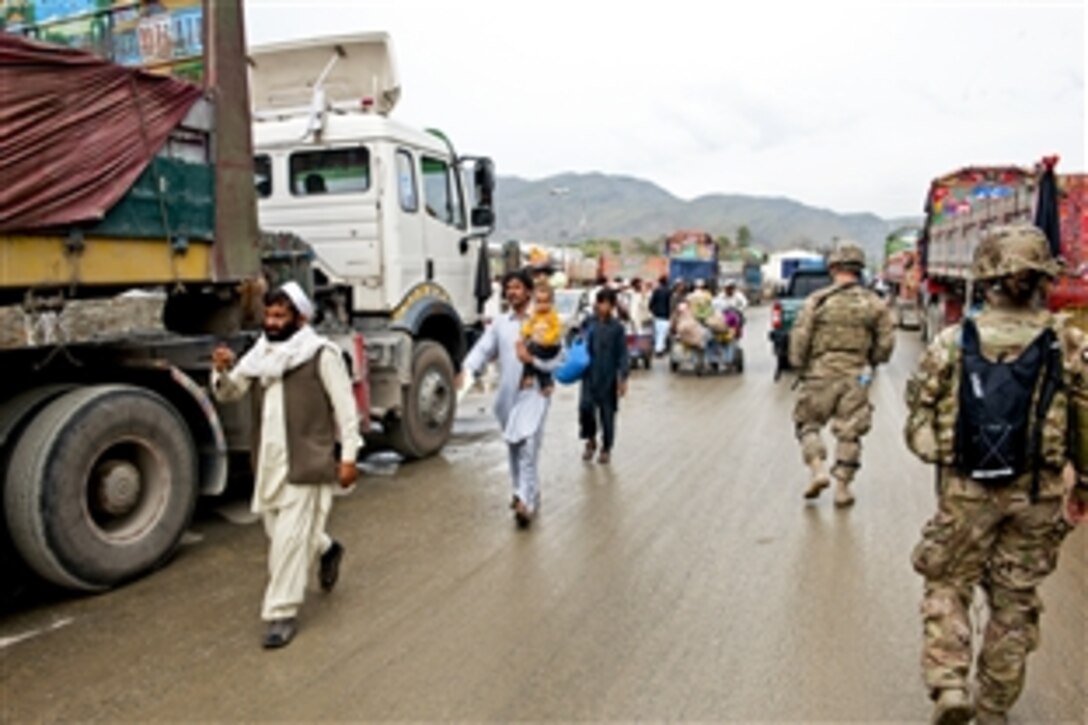 U.S. soldiers patrol near traffic from Pakistan at the Torkham Gate customs checkpoint in Afghanistan's Nangarhar province, April 24, 2013. 