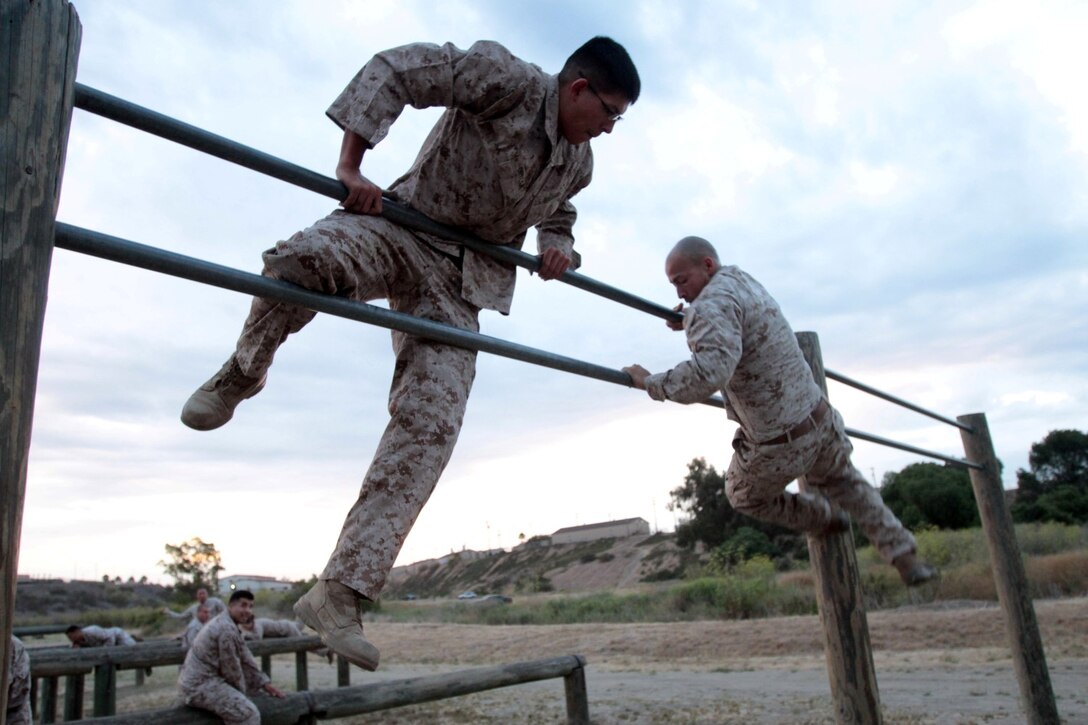 MARINE CORPS BASE CAMP PENDLETON, Calif. – Lance Cpl. Ismael E. Ortega, left, combat photographer, and Cpl. Bobby J. Gonzalez, combat videographer, both with Headquarters and Service Company, Headquarters Battalion, 1st Marine Division, maneuver over the double bars at the obstacle course at Camp Margarita here, July 26, 2013. Ortega, a native of El Paso, Texas, and Gonzalez, a native of Weslaco, Texas, both deployed to Afghanistan with various units. As members of 1st Marine Division, they must remain physically prepared to attach to units throughout the division.
(U.S. Marine Corps photo by Sgt. Jacob H. Harrer)