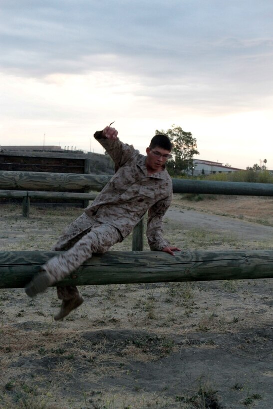 MARINE CORPS BASE CAMP PENDLETON, Calif. – Lance Cpl. Ismael E. Ortega, combat photographer, Headquarters and Service Company, Headquarters Battalion, 1st Marine Division, bounds over a log at the obstacle course at Camp Margarita here, July 26, 2013. Ortega, a native of El Paso, Texas, deployed to Afghanistan with 2nd Battalion, 5th Marine Regiment in support of Operation Enduring Freedom. Marines with Headquarters Battalion often attach to combat arms units for deployments to Afghanistan, so they must maintain a high state of physical readiness. 
(U.S. Marine Corps photo by Sgt. Jacob H. Harrer)