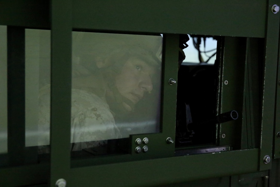 MARINE CORPS BASE CAMP PENDLETON, Calif. – Lance Cpl. Kyle Kirby, rifleman, 1st Combined Anti-Armor Team, 2nd Battalion, 5th Marine Regiment, and native of Chicago, searches out the window of a Humvee for virtual improvised explosive devices and enemy insurgents during a simulated convoy in the Combat Convoy Simulator here, July 25, 2013. The CCS provides an immersive training environment for both convoy operations training and command and control procedures for vehicle and convoy commanders in tactical scenarios. The CCS places Marines in a realistic environment and allows for repetition, review and critique while saving time, maintenance, ammunition, weapons and range facilities.