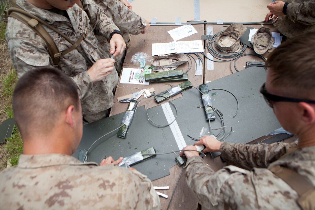 Marines with 2nd and 4th Combat Engineer Battalions and 8th Engineer Support Bn. create charges with C-4 during practical application day prior to the urban demolition range here, July 23, 2013.  The Marines were required to create each type of shaped charge they were going to utilize, in different environments and against different substances like wood and concrete. (U.S. Marine Corps photo by Cpl. Marcin Platek/Released)