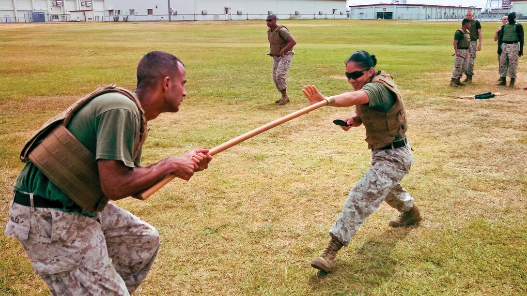 Cpl. Angie Pazmino, right, practices approaching a bayonet-armed assailant July 24 at Camp Foster during a martial arts instructor course. The course, facilitated by the Marine Corps martial arts program's Martial Arts Center for Excellence, helped Marines attain the next level of MCMAP training, as well as added to their repertoire of leadership techniques, according to Pazmino, a student of the MACE’s mobile training team. second-degree black belt course and ground-training noncommissioned officer with Marine Medium Helicopter Squadron 262, Marine Aircraft Group 36, 1st Marine Aircraft Wing, III Marine Expeditionary Force. Photo by Lance Cpl. Pete Sanders
