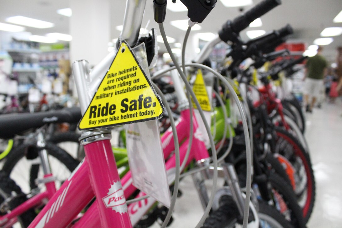 A sign attached to a bicycle reminds riders that helmets are required when riding on military installations. While participating in summer activities, safety must be implemented by using personal protective equipment such as helmets. PPE provides an invaluable source of protection to minimize injury, according to Aaron M. Davis, the supervisory occupational safety and health specialist with the Installation Safety Office, Marine Corps Installations Pacific and Marine Corps Base Camp Smedley D. Butler. (U.S. Marine Corps photo by Lance Cpl. Nicholas S. Ranum/Released)