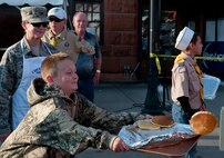 Col. Tracey Hayes, 90th Missile Wing commander, watches her son, James, catch a volunteer cook-flipped pancake on a tray during a pancake breakfast, which was part of the 117th Annual Cheyenne Frontier Days, July 24, 2013, at the Cheyenne Depot Square, Wyo. The traditional free pancake breakfast is a volunteer-run event occurring three times throughout CFD, serving more than 100,000 pancakes and 3,000 pounds of ham. (U.S. Air Force photo by R.J. Oriez)
