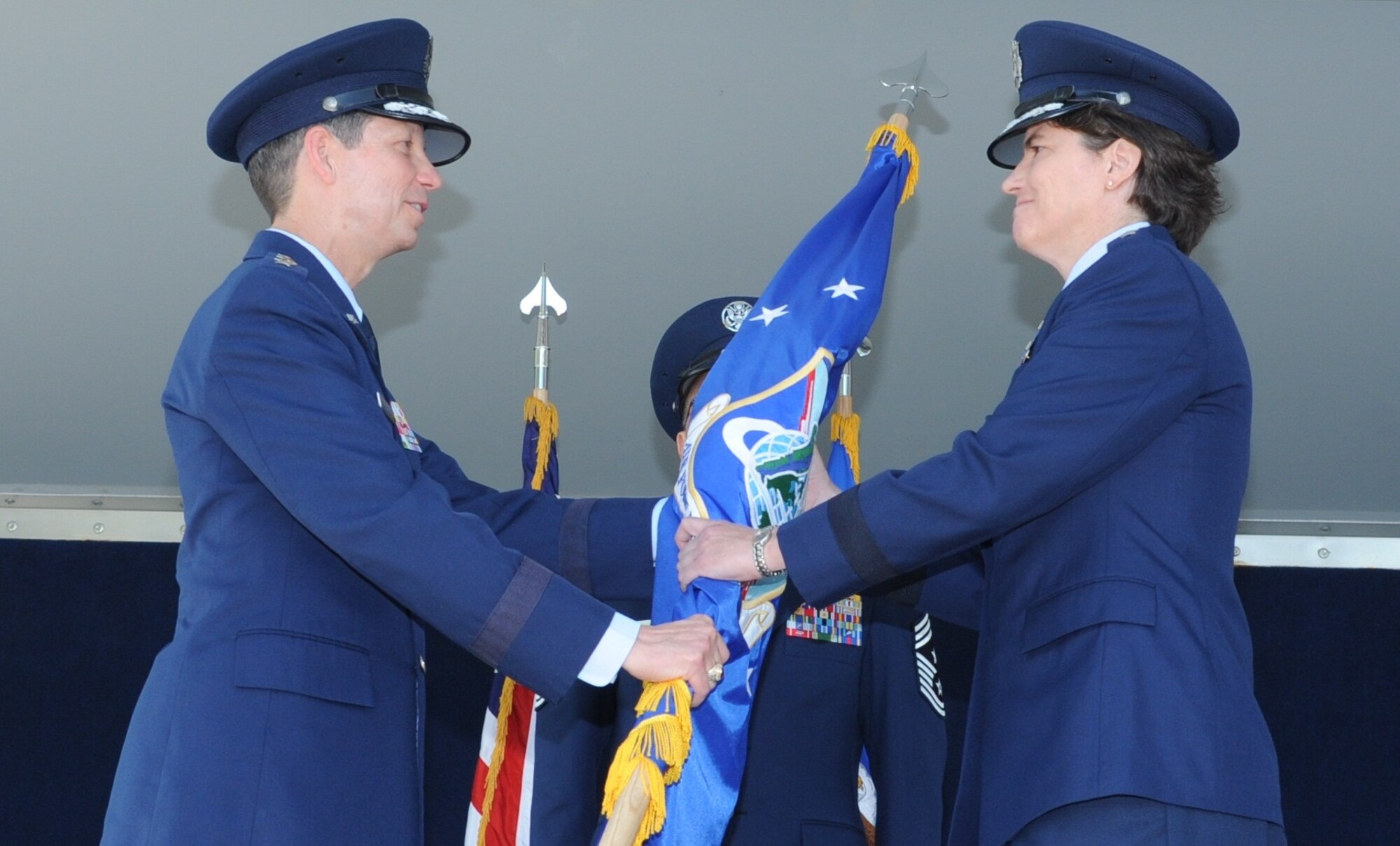 Maj. Gen. Peggy Poore (right) accepts the Air Force Personnel Center guidon from Lt. Gen. Darrell Jones, the Air Force deputy chief of staff for manpower, personnel and services, during the AFPC change of command ceremony Aug. 1, 2013, at Joint Base San Antonio-Randolph, Texas. Relinquishing command was Maj. Gen. A.J. Stewart, who commanded AFPC since Aug. 6, 2010. (Courtesy Photo)