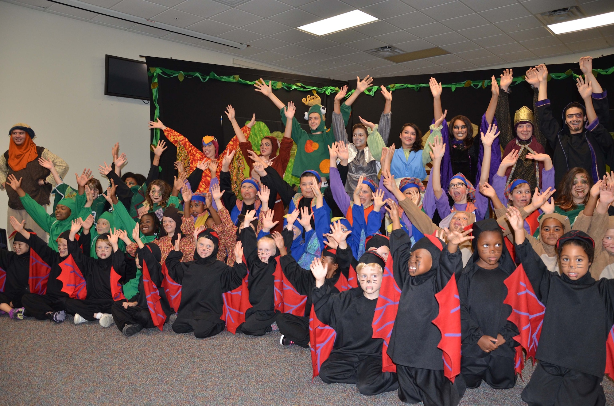 Children from the Patrick AFB Youth Center celebrate their performance of "Snow White and the Seven Dwarfs" July 26, 2013 in a grand finale that brought all the characters on stage for a final curtain call.  The play was a production of Missoula Children's Theater, a travel theater company that spends a week at a time at venues across America introducing children to the performing arts.  More than 50 school-age children from the Patrick community participated in the program.  (U.S Air Force photo by Susan A. Romano)
