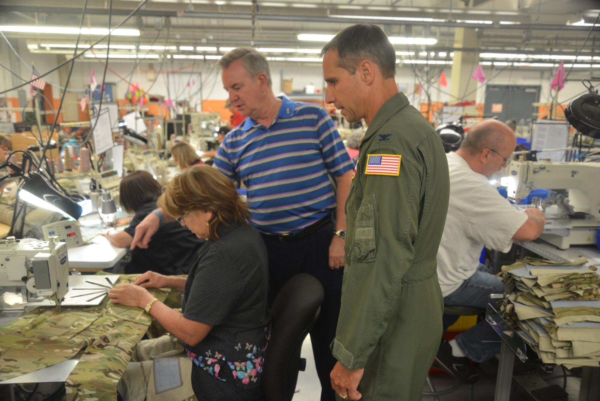 In the sewing department of the San Antonio Lighthouse for the Blind, Amelia Cantu sews an Army Combat Shirt, as Mike Gilliam, president and CEO of the SALB describes all the items that SALB manufactures for the military, such as helmet chin-straps for the Army and Marines, and the Army’s Combat Shirt. (U.S. Air Force photo by Senior Master Sgt. Minnie Jones)