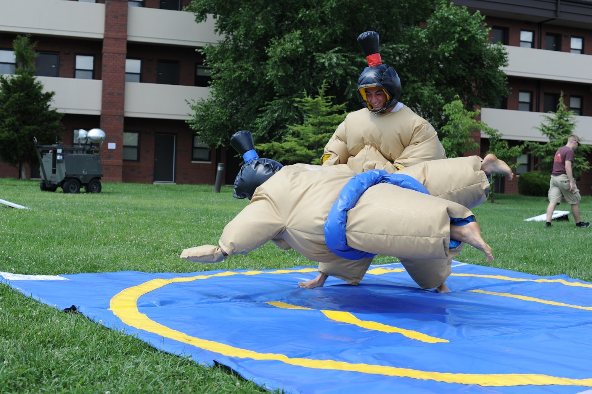 Airman 1st Class Dustin Bawell, 305th Maintenance Squadron crew chief, attempts to take down Airman 1st Jake Vuyovich, 305th MXS crew chief, during a sumo-wrestling match at the second annual Dorm-a-Palooza July 26, 2013, at Joint Base McGuire-Dix-Lakehurst, N.J. Local organizations sponsored the event to afford junior service members an opportunity to enjoy food, games and music for free. (U.S. Air Force photo by Airman 1st Class Sean M. Crowe/Released)