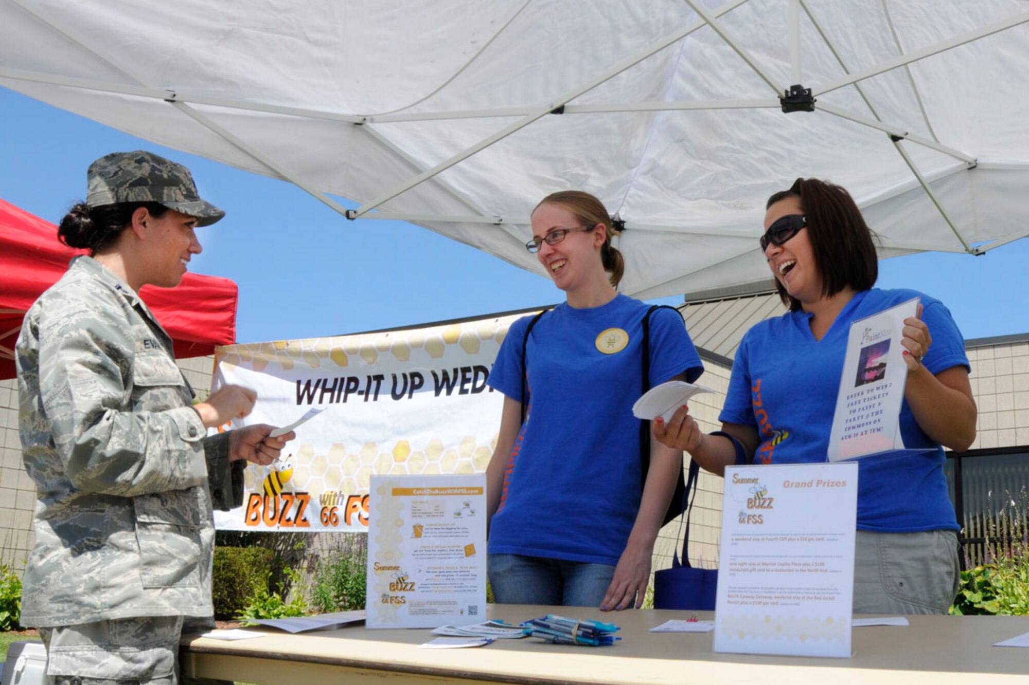 HANSCOM AIR FORCE BASE, Mass. – Capt. Laura Evans receives an entry form for a drawing during a “Whip It Up Wednesday” promotion near the Hanscom Federal Credit Union as Emily McNamara and Vanessa Pearson look on July 31. The 66th Force Support Squadron holds the weekly event at locations around base. Food from the Minuteman Commons’ new caterer is available for purchase as well as prizes given. (U.S. Air Force photo by Linda LaBonte Britt)