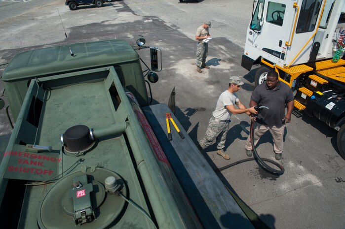 Airman 1st Class Christopher Castro, 628th Logistics Readiness Squadron Petroleum Oil and Lubricants fuels specialist, assists a customer with refueling a vehicle July 25, 2013, at Joint Base Charleston- Weapons Station, S.C. POL fuels supplies JB Charleston vehicles with fuel, including rail operations, cranes on Wharf Alpha to offload ships, port operations on the water, the 628th Security Forces Squadron and the U.S. Coast Guard. The 628th LRS has been providing this service since October 2010. A new service station is under construction at the Weapons Station and is scheduled to open later this year.   (U.S. Air Force photo/Senior Airman Ashlee Galloway)