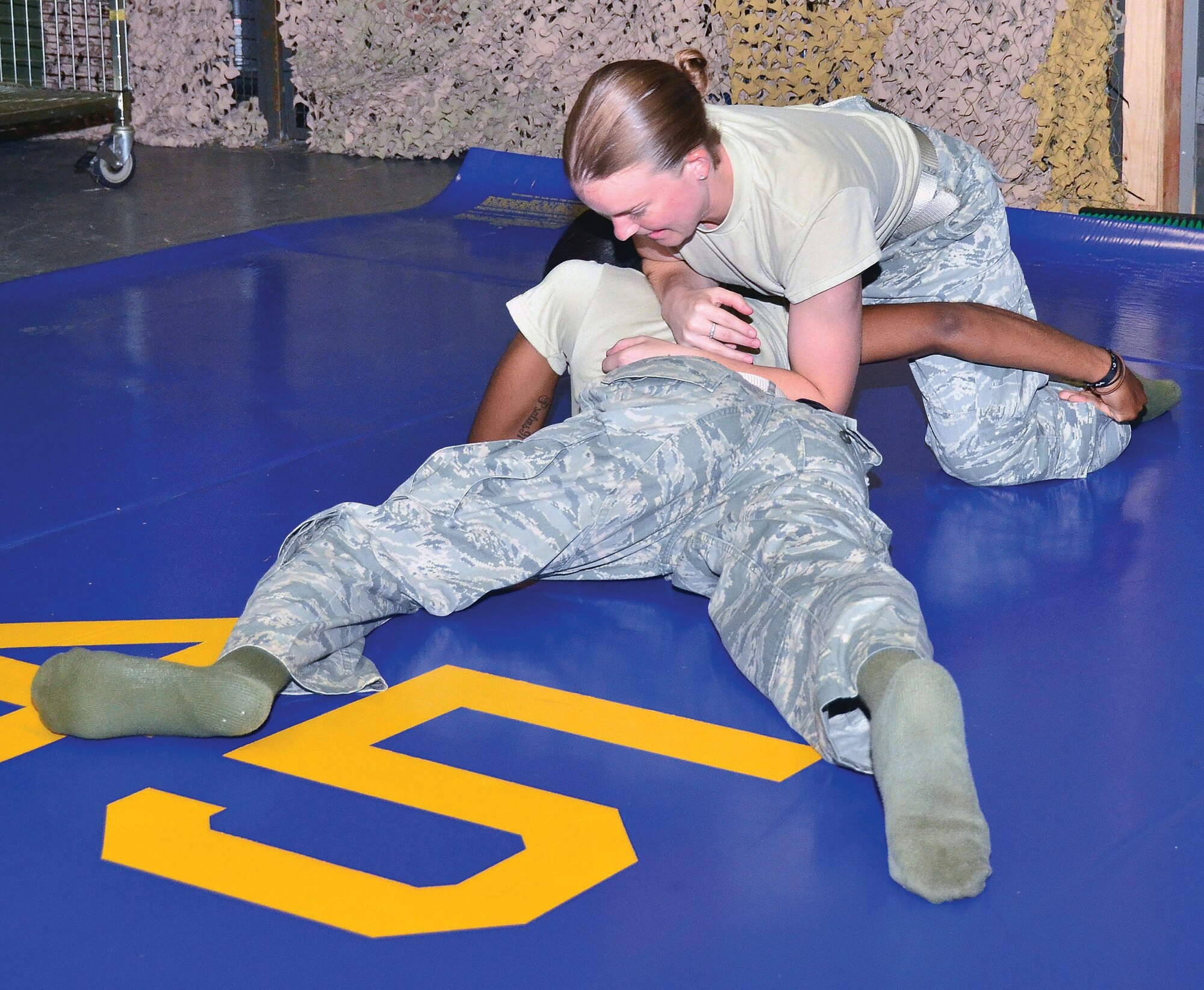 WRIGHT-PATTERSON AIR FORCE BASE, Ohio – Staff Sgts. Dawn Gettys and Cazavia Henley, 445th Security Forces Squadron, practice Combative Security Forces Self-Defense during the July 13 unit training assembly. All security forces members are required to participate in the training. New SFS members or those directly out of technical school have a 20-hour initial training followed by 10 hours of annual training to remain qualified. This training is specifically for SFS and is different from Army and Air Force combative training. (U.S. Air Force photo/Staff Sgt. Amanda Duncan)