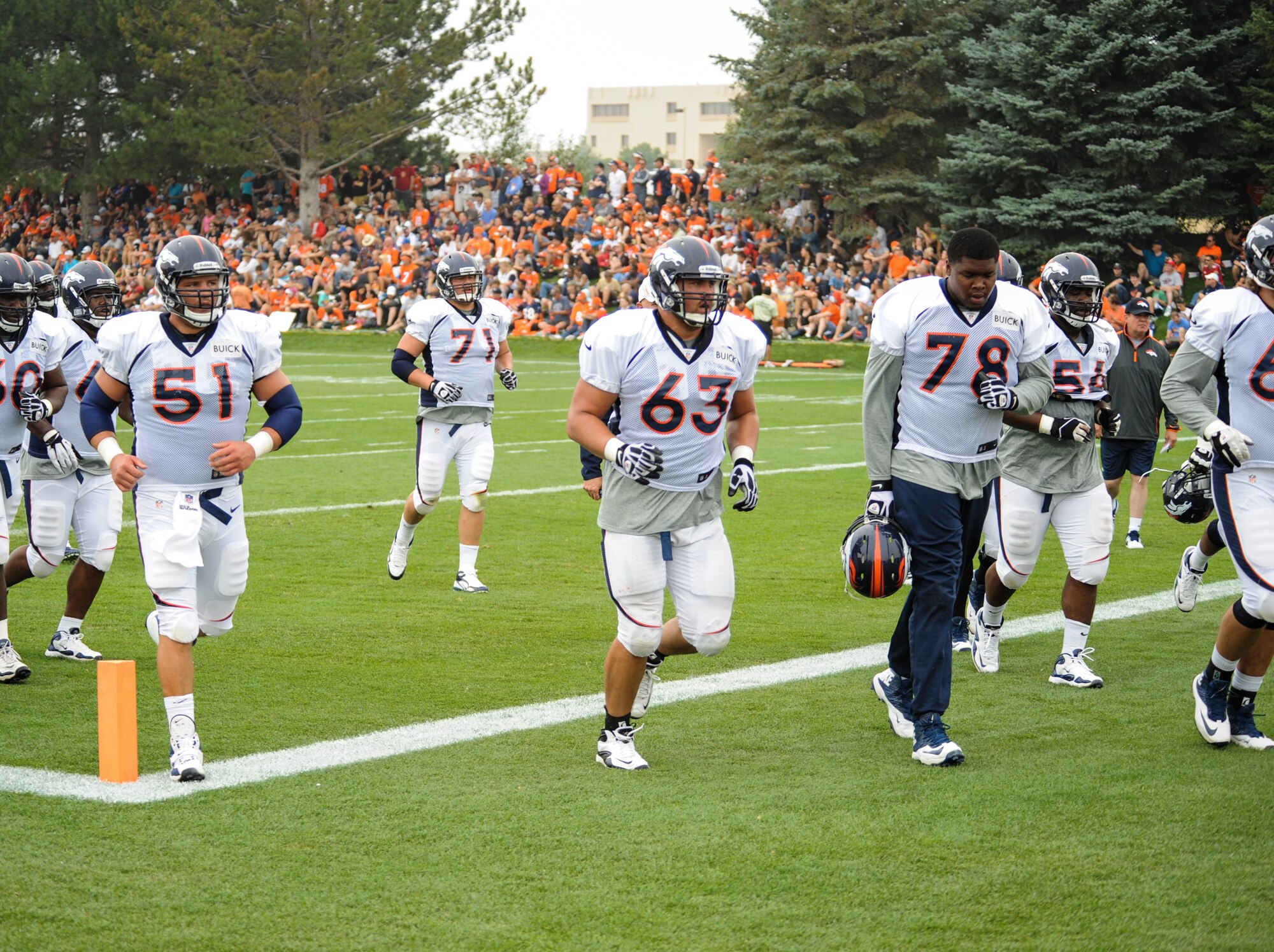 Benjamin Garland, Denver Broncos offensive guard, 63, runs to the next drill with the rest of his offensive line members during a Broncos training camp practice July 29, 2013, at the Broncos training facility, Englewood, Colo. Garland spent last season on the Broncos practice squad and transitioned from defensive tackle to offensive guard before the Broncos 2013 mini-camp. Garland is also a first lieutenant for the 140th Wing, Colorado Air National Guard, and served his annual commitment during the early part of 2013. (U.S. Air Force photo by Staff Sgt. Christopher Gross/Released)