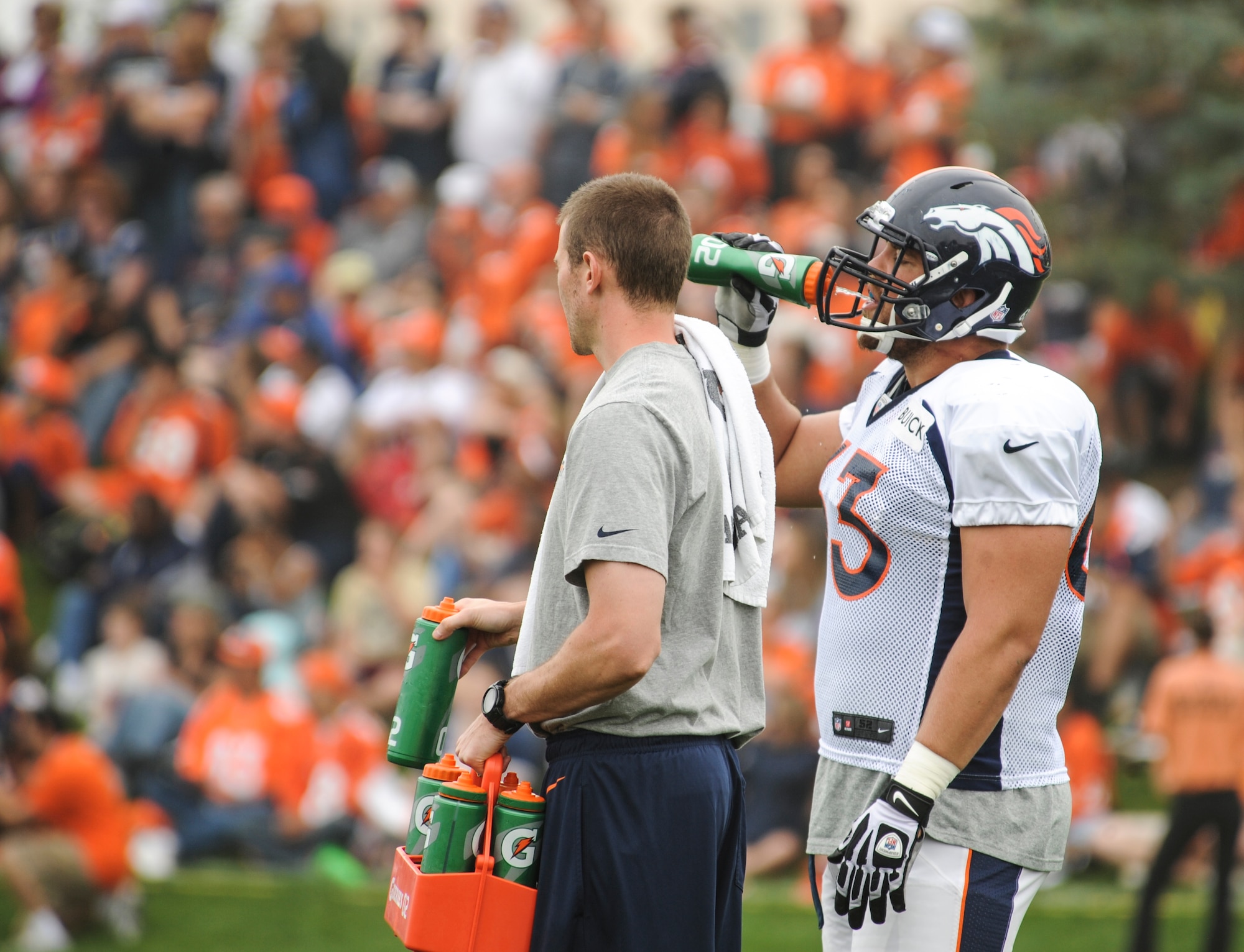 Benjamin Garland, Denver Broncos offensive guard, right, takes a water break during offensive line drills at a Broncos training camp practice July 29, 2013, at the Broncos training facility, Englewood, Colo. Garland spent last season on the Broncos practice squad and transitioned from defensive tackle to offensive guard before the Broncos 2013 mini-camp. Garland is also a first lieutenant for the 140th Wing, Colorado Air National Guard, and served his annual commitment during the early part of 2013. (U.S. Air Force photo by Staff Sgt. Christopher Gross/Released)