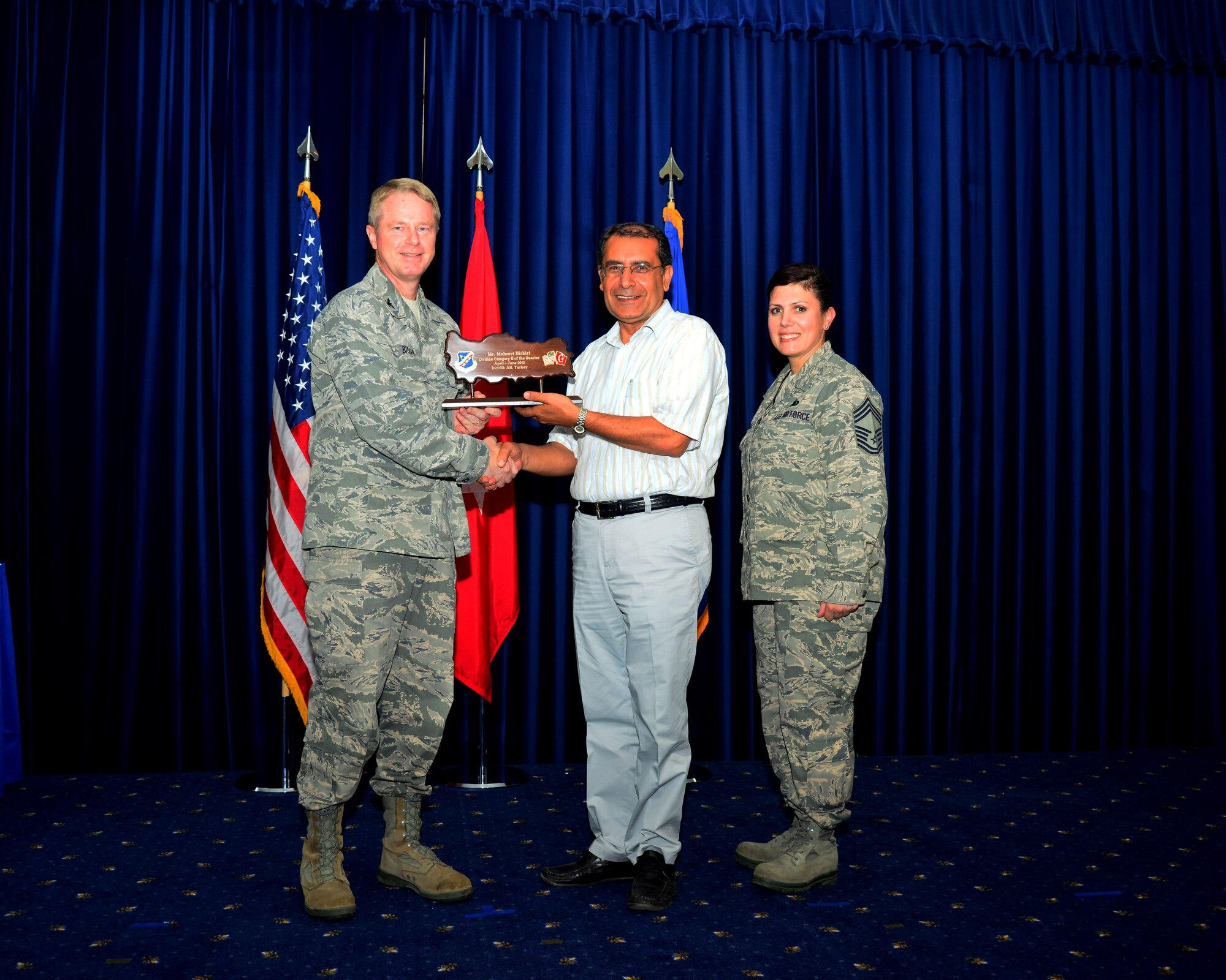 Mehmet Birbiri, 39th Air Base Wing, receives his award for winning the second quarter civilian category two from Col. Brent Bigger, 39th Air Base Wing vice commander, during the promotion and awards ceremony July 31, 2013, at Incirlik Air Base, Turkey. The award and promotion ceremony is held to recognize the wing’s quarterly award winners and monthly Airmen promotions. (U.S. Air Force photo by Staff Sgt. Eric Summers Jr./Released)
