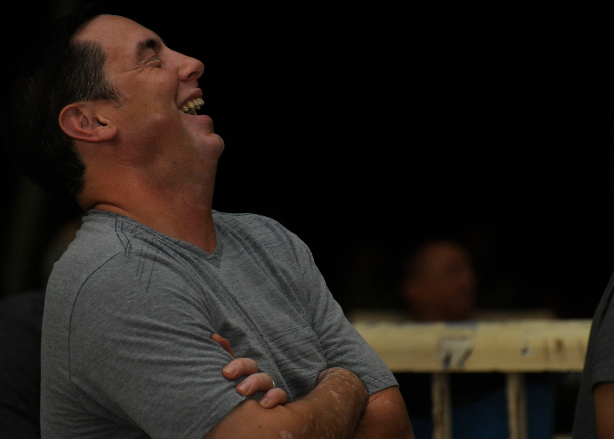 Navy Lt. Robert Holihan laughs heartily during Don Barnhart’s All-Star Comedy tour performance presented by Armed Forces Entertainment at the 379th Air Expeditionary Wing in Southwest Asia, July 28, 2013. Holihan is a Tactical Air Control Squadron 22 Expeditionary Strike Group liaison naval officer deployed from Joint Expeditionary Base Little Creek-Fort Story, Va. (U.S. Air Force photo/Senior Airman Bahja J. Jones)