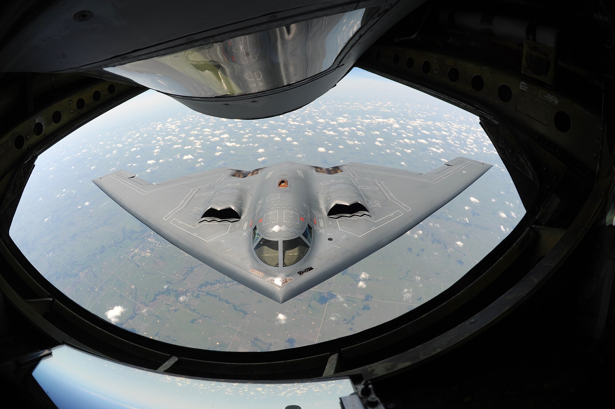 A B-2 Spirit Stealth Bomber approaches the rear of a KC-135 Stratotanker in preparation to refuel during a training mission over Midwestern skies,  Aug. 1, 2013. The B-2’s unique design has enabled it to travel into enemy territory without being detected by their radar to deploy ordinance. It is one of many aircraft McConnell’s tankers provide fuel to. (U.S. Air Force Photo/Airman 1st Class John Linzmeier)