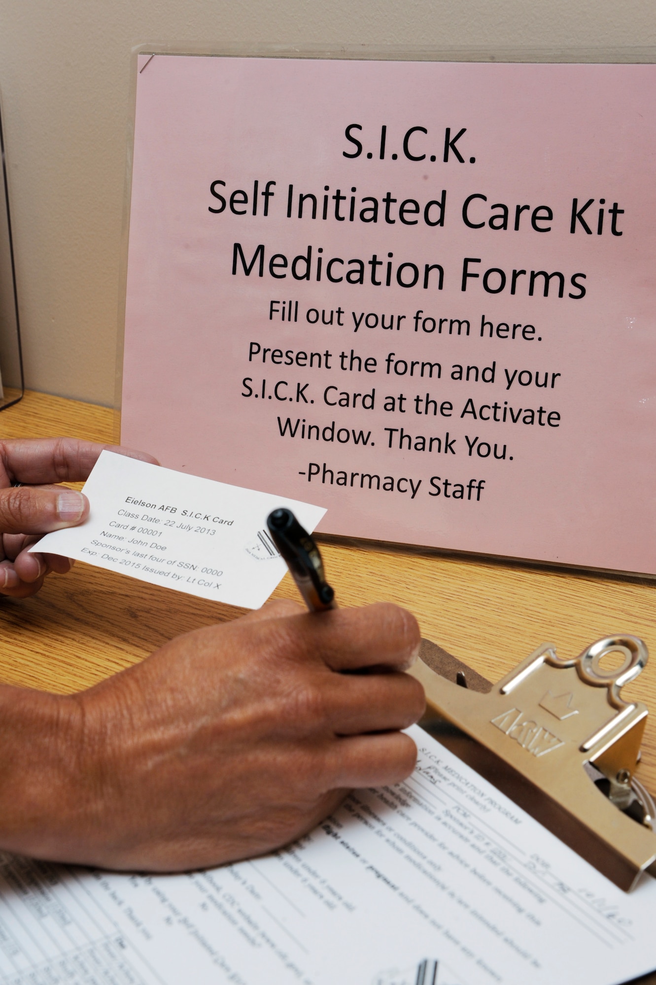 A holder of the Self-Initiated Care Kit card fills out a prescription request form at the 354th Medical Group in order to acquire free medications for minor illnesses.  The S.I.C.K. program saves patients and physicians time and money by enabling people to self diagnose ailments which do not require specialized treatment.  (U.S. Air Force Photo by Airman First Class Peter Reft/Released)