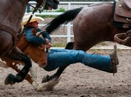 Trell Etbauer of Goodwill, Okla., grabs the steer by the horns during the steer wrestling event on the opening day of 117th annual Cheyenne Frontier Days Saturday, July 20, 2013. The rodeo is the highlight of the huge 10-day event that is highly dependent on volunteers, including F.E. Warren Air Force Base Airmen, for its success. (U.S. Air Force photo by R.J. Oriez)