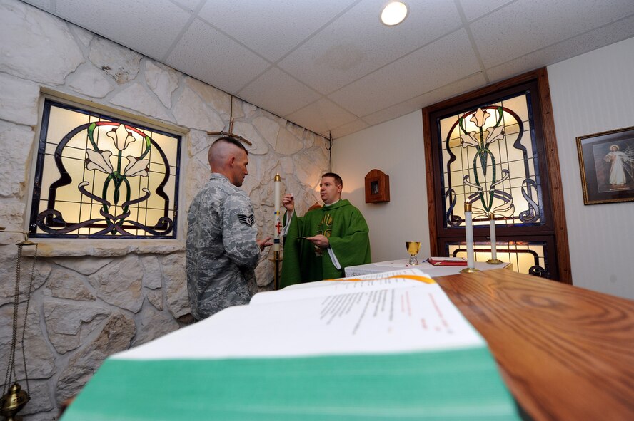 Staff Sgt. William Curtiss, 341st Missile Wing chaplain’s assistant, receives a communion wafer from Chaplain (Capt.) Matthew Glaros. Catholic services are held daily at 11:15 a.m., on Saturdays at 5 p.m. and Sundays at 9 a.m. Reconciliation is held Saturdays at 4 p.m. and Sunday through Friday by appointment only. Protestant services are held Sundays at 11:15 a.m. (U.S. Air Force photo/Staff Sgt. R.J. Biermann) 
