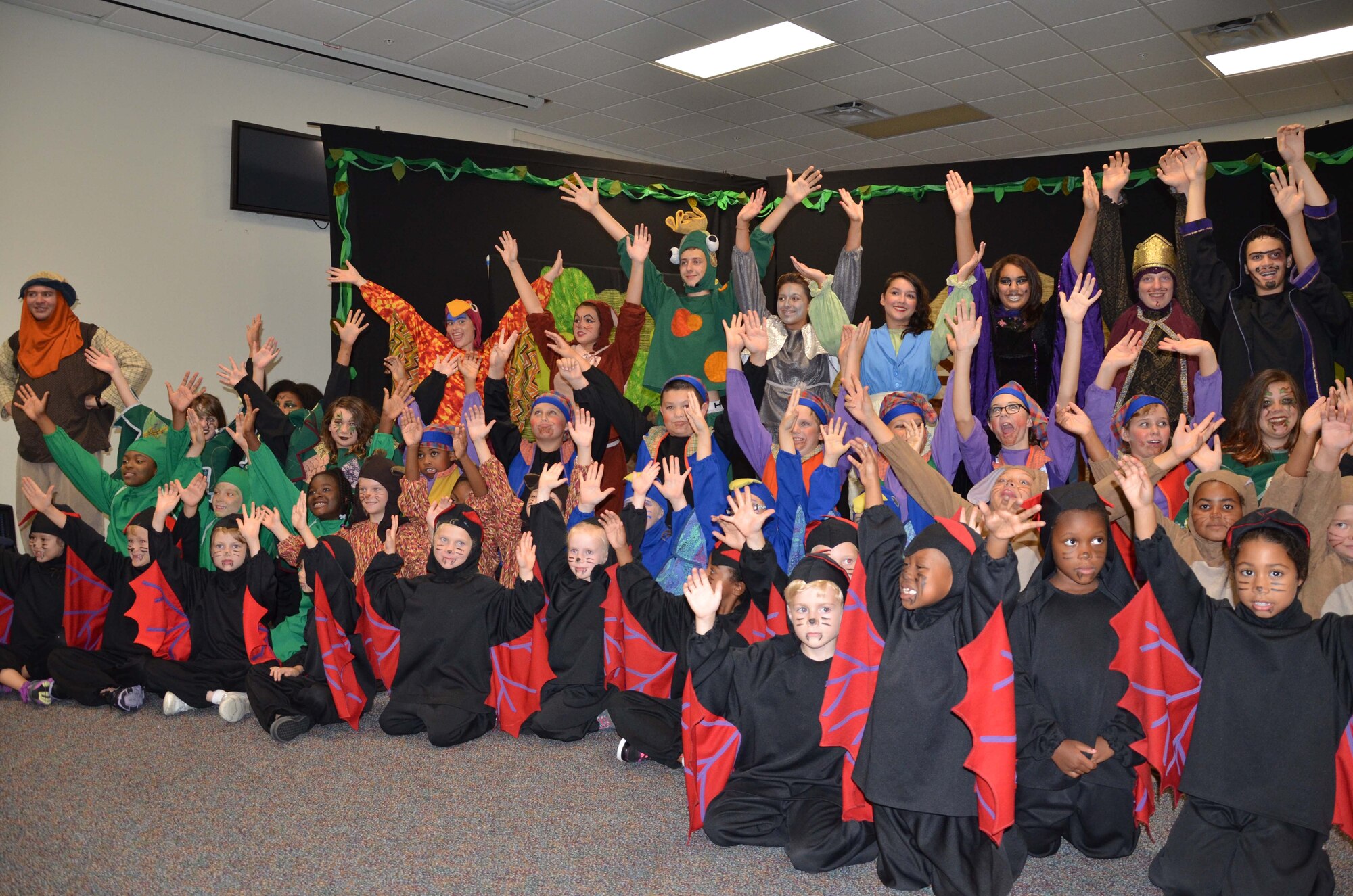 Children from the Patrick AFB Youth Center celebrate their performance of "Snow White and the Seven Dwarfs" July 26, 2013 in a grand finale that brought all the characters on stage for a final curtain call.  The play was a production of Missoula Children's Theater, a travel theater company that spends a week at a time at venues across America introducing children to the performing arts.  More than 50 school-age children from the Patrick community participated in the program.  (U.S Air Force photo by Susan A. Romano)
