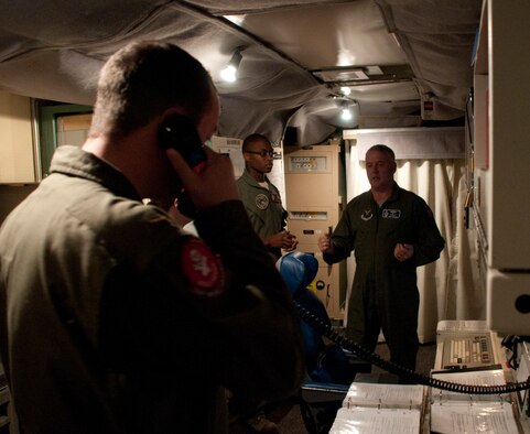 Second Lt. Nicholas Tramutolo, 320th Missile Squadron deputy missile combat crew commander, answers a phone to discuss duty-related matters while Capt. Keidrick Roy, 320th MS missile combat crew commander, speaks with Maj. Gen. Michael Carey, 20th Air Force commander, in the launch control center of the Foxtrot-01 Missile Alert Facility July 29, 2013. (U.S. Air Force photo by Airman 1st Class Jason Wiese)
