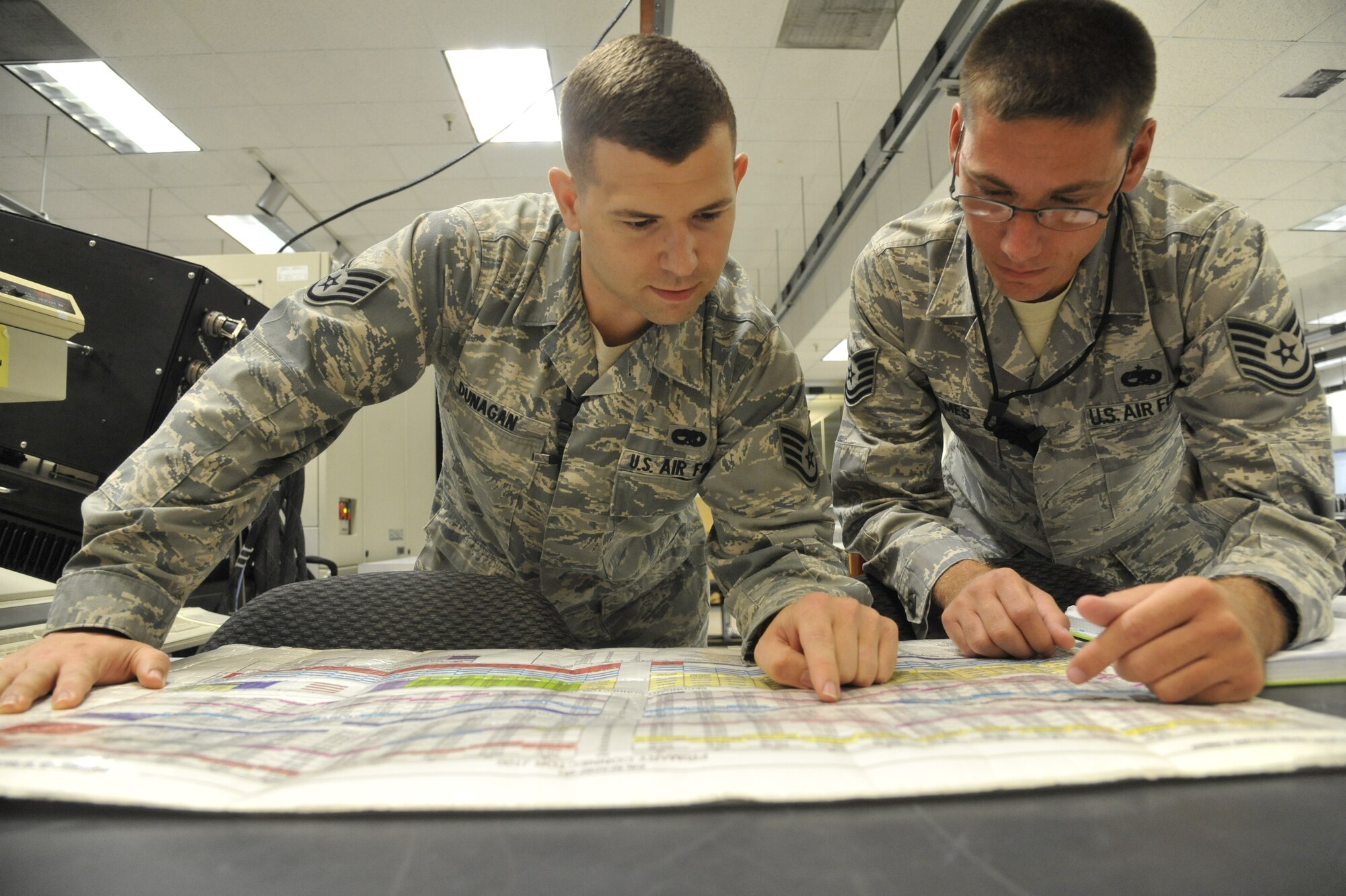 Staff Sgt. Reagan Dunagan, 509th Maintenance Squadron avionics back shop team leader, and Tech. Sgt. Jeffrey Holmes, 509th MXS avionics back shop section chief, examine a pin map at Whiteman Air Force Base, Mo., July 25, 2013. The pin map is used to help isolate faults and show where signals from test stations are coming from. (U.S. Air Force photo by Airman 1st Class Keenan Berry/Released)