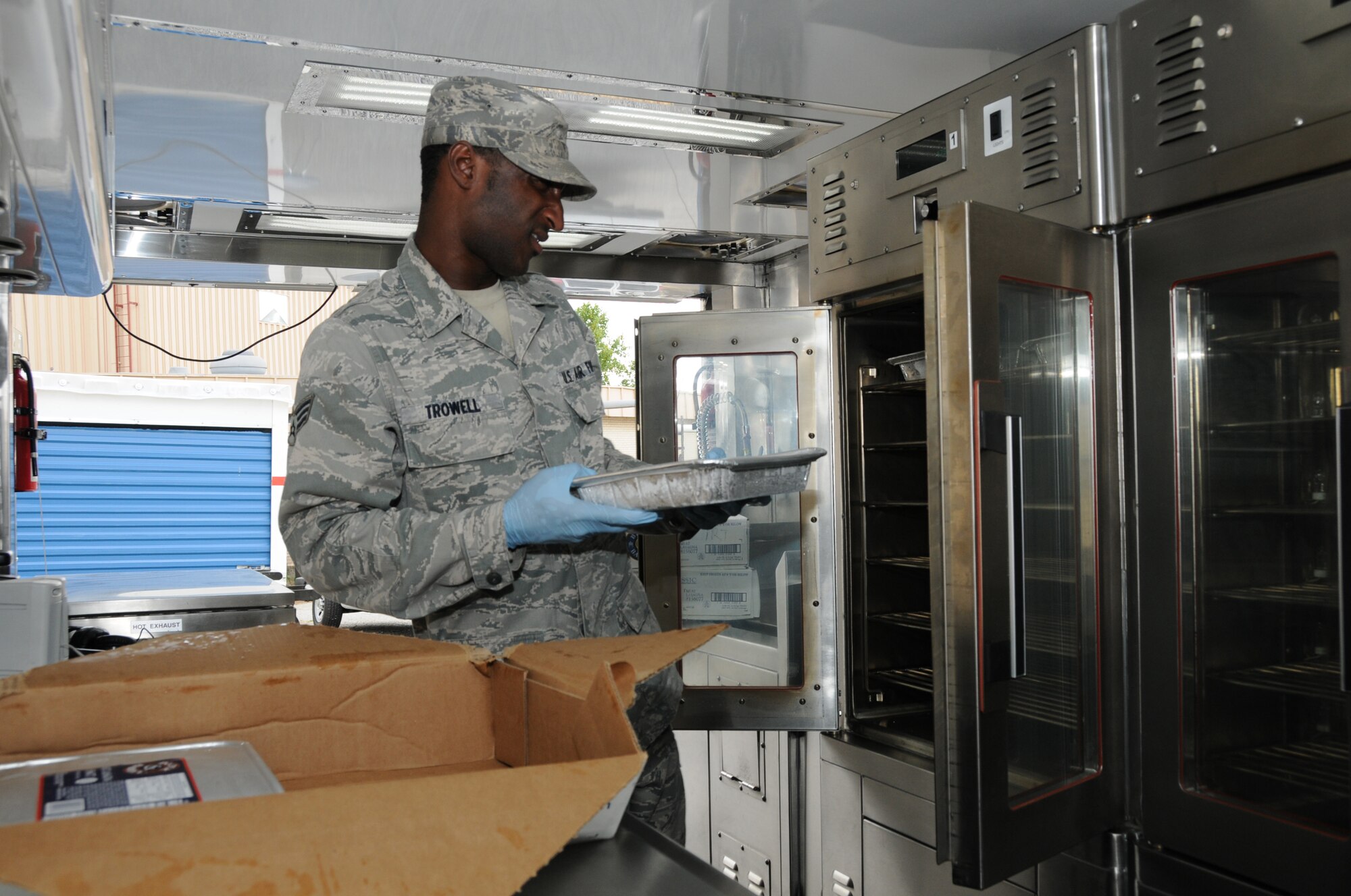U.S. Air Force Senior Airman Dwight Trowell, Force Support Flight, 123d Airlift Wing, Louisville, Kentucky, loads lasagna meals in the oven of a Disaster Response Mobile Kitchen Trailer (DRMKT) July 15 at ‘Hope of Martin’ Innovative Readiness Training held at Martin Middle School in Martin, Tenn. (U.S. Air National Guard photo by Master Sgt. Carlos J. Claudio/Released).