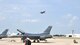 Two members of the 301st Maintenance Group look on as an F-16 takes off from Alliance Airport. Flight operations began July 31 as the runway at Naval Air Station Fort Worth Joint Reserve Base, Texas, is closed to allow much-needed repairs to the airfield.  (U.S. Air Force Photo/Capt. Rodney Ellison, 301st FW Public Affairs Officer)