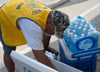 Retired Army Sgt. 1st Class Ventura Mancha, commander of the Veterans of Foreign Wars Post 8852, fills a cooler with ice and water for Laughlin’s volunteers in Del Rio, Texas, July 27, 2013. Laughlin had more than 70 volunteers help out with painting the building. (U.S. Air Force Photo/Airman 1st Class Jimmie D. Pike)
