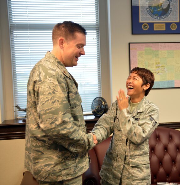 Senior Airman Junelee De Pio, 62nd Airlift Wing executive administrative support journeyman, is surprised by Maj. Neil Harris, 62nd Comptroller Squadron commander, as he congratulates her for being selected to the rank of staff sergeant August 1, 2013 at Joint Base Lewis-McChord, Wash. De Pio is one of the 96 senior airmen from the 62nd AW who received notification of their selection to the rank of staff sergeant. (U.S. Air Force photo/Staff Sgt. Jason Truskowski)
