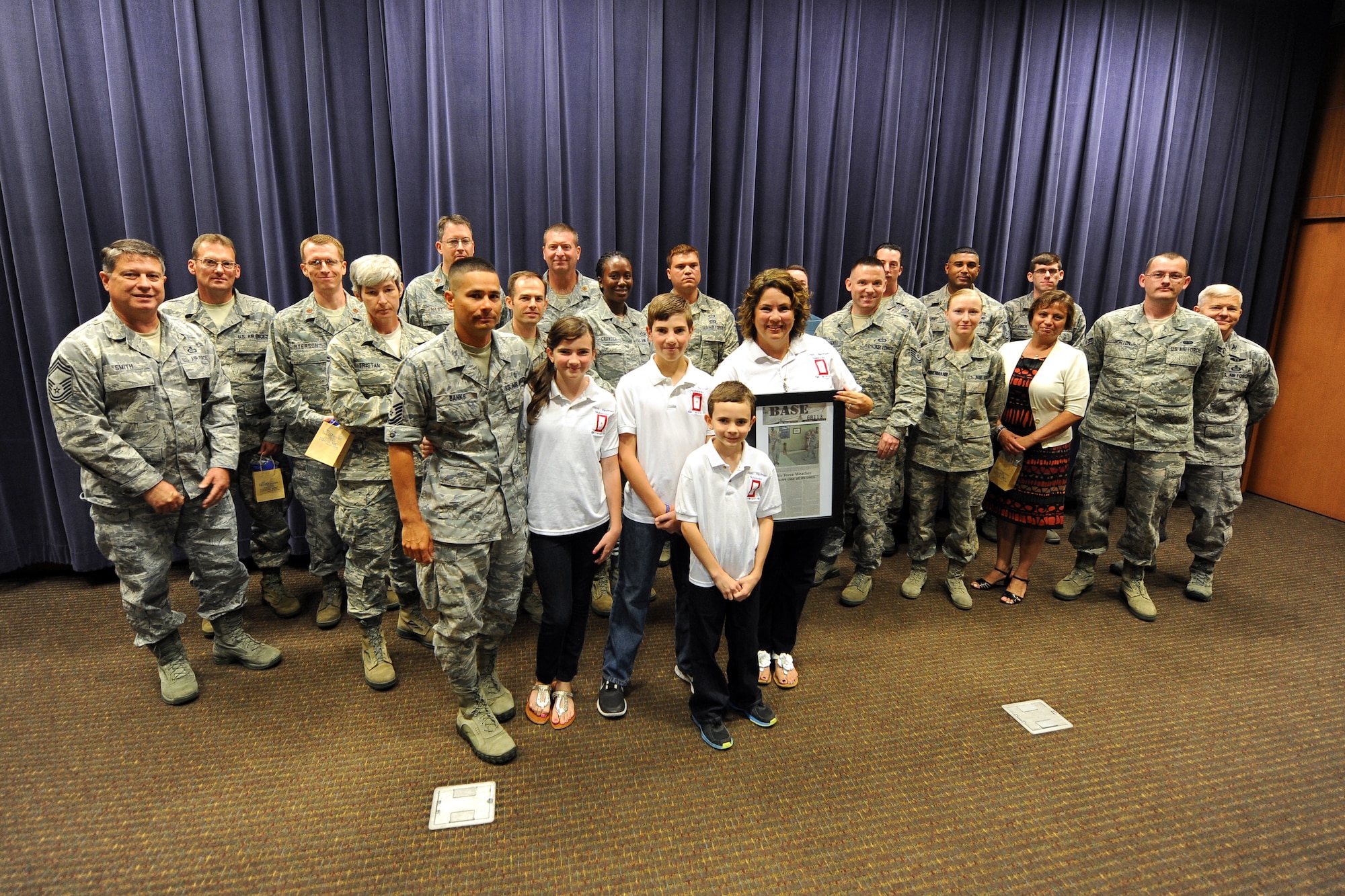 Miriam Hamilton and her family pose for a photo at the Air Force Weather Agency at Offutt Air Force Base, Neb., on July 19 with some of the volunteers who served in the 24-hour vigil honoring her late husband, U.S. Air Force Capt. Nathan Nylander, on the second anniversary of his death. Nylander was a weather officer who was killed in Afghanistan along with eight others during a shooting at Kabul International Airport on April 27, 2011. (Photo by Josh Plueger)