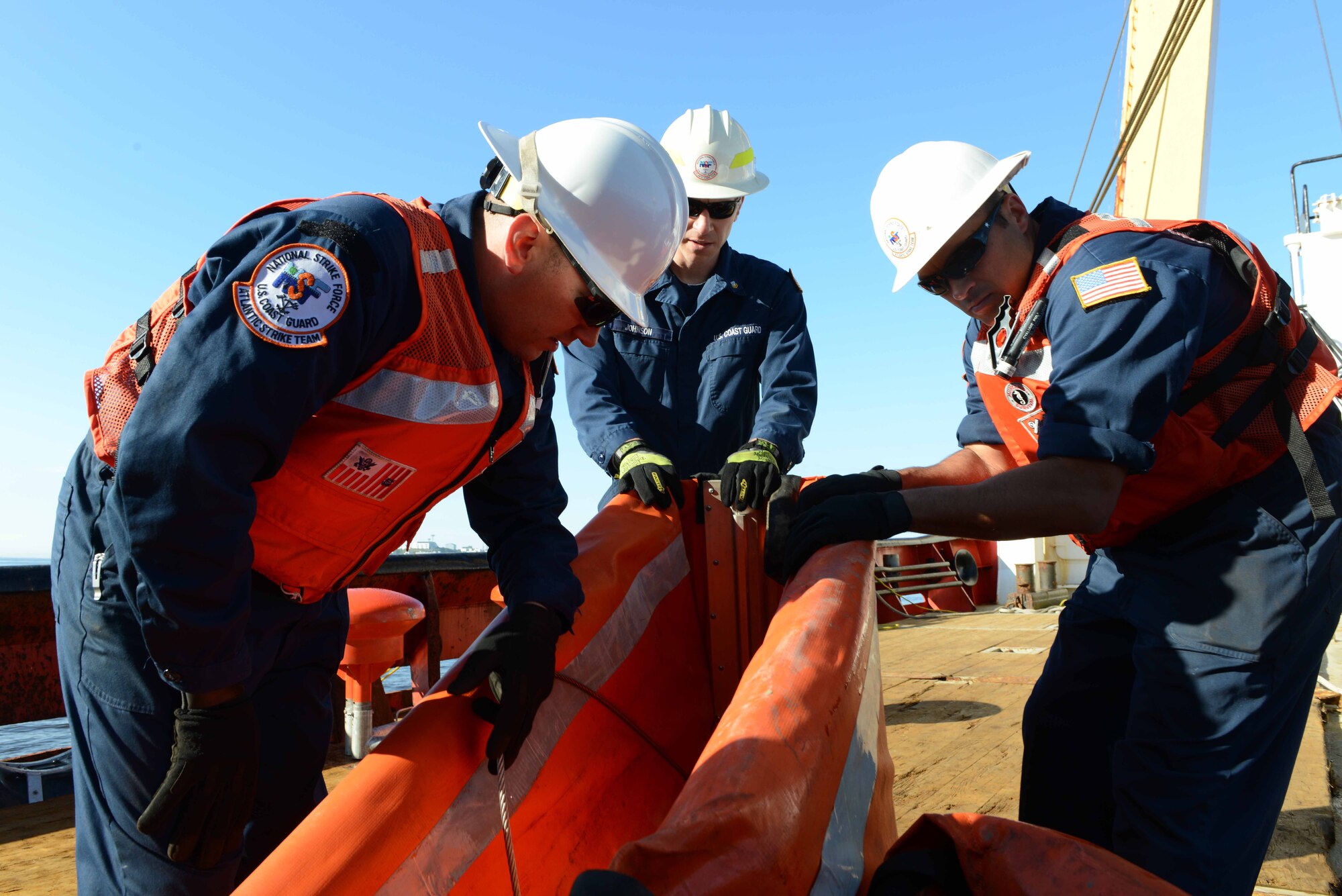 Chief Petty Officer Michael Presti, Petty Officer First Class James Maida and Petty Officer Second Class Andrew Johnson assemble the foam filled boom for deployment onboard the Cutter Edward Cornwallis June 18, 2013, near Saint John, Canada. The biennial exercise is designed to test response portions of the Joint Marine Pollution Contingency Plan, focusing on the Atlantic Coast and to strengthen partnerships and interoperability between the U.S. and Canada. (U.S. Coast Guard photo by Lt. Kristen Potter/Released)