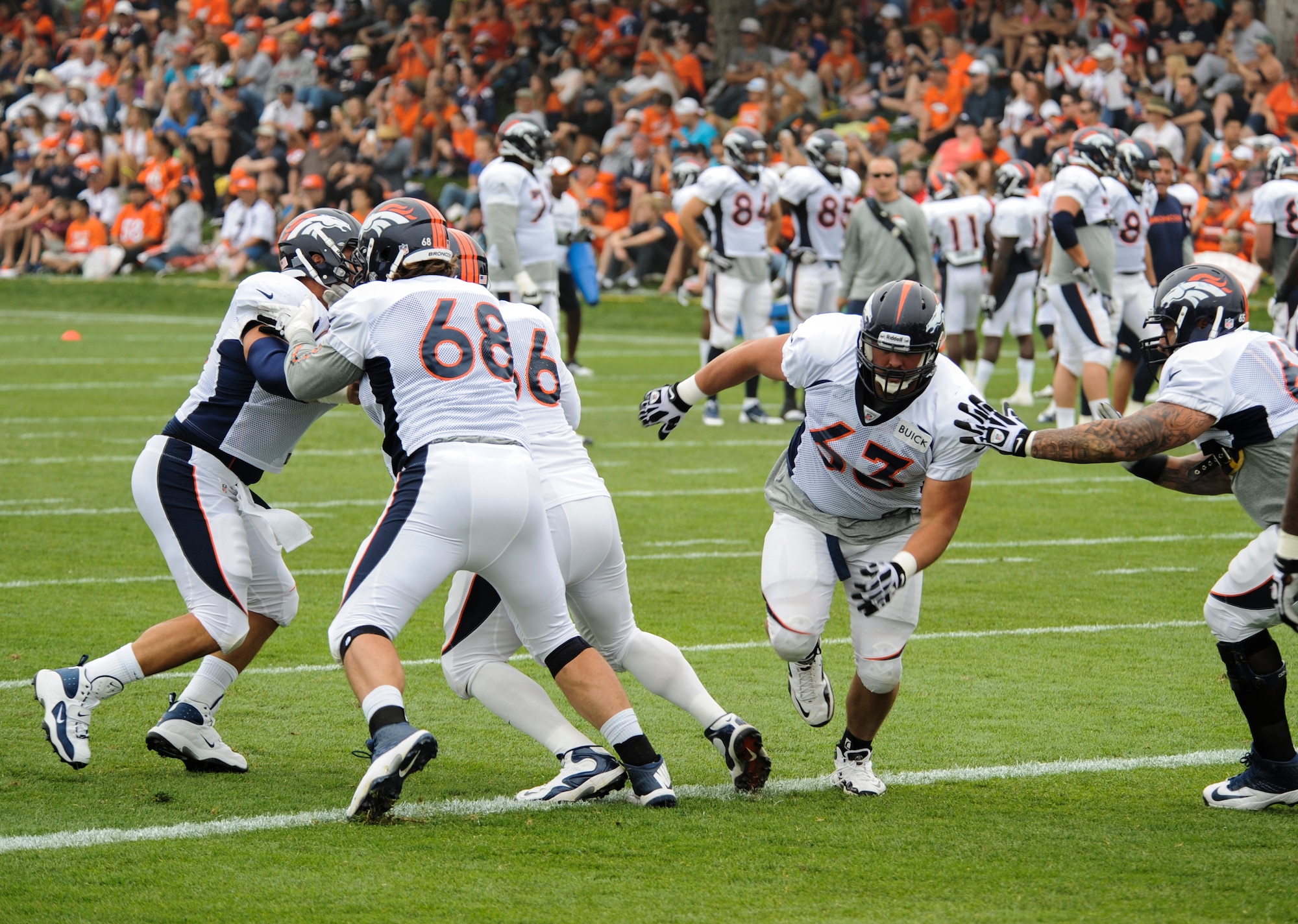 Benjamin Garland, Denver Broncos offensive guard, 63, rushes through the line during an offensive line drill at a Broncos training camp practice July 29, 2013, at the Broncos training facility, Englewood, Colo. Garland spent last season on the Broncos practice squad and transitioned from defensive tackle to offensive guard before the Broncos 2013 mini-camp. Garland is also a first lieutenant for the 140th Wing, Colorado Air National Guard, and served his annual commitment during the early part of 2013. (U.S. Air Force photo by Staff Sgt. Christopher Gross/Released)