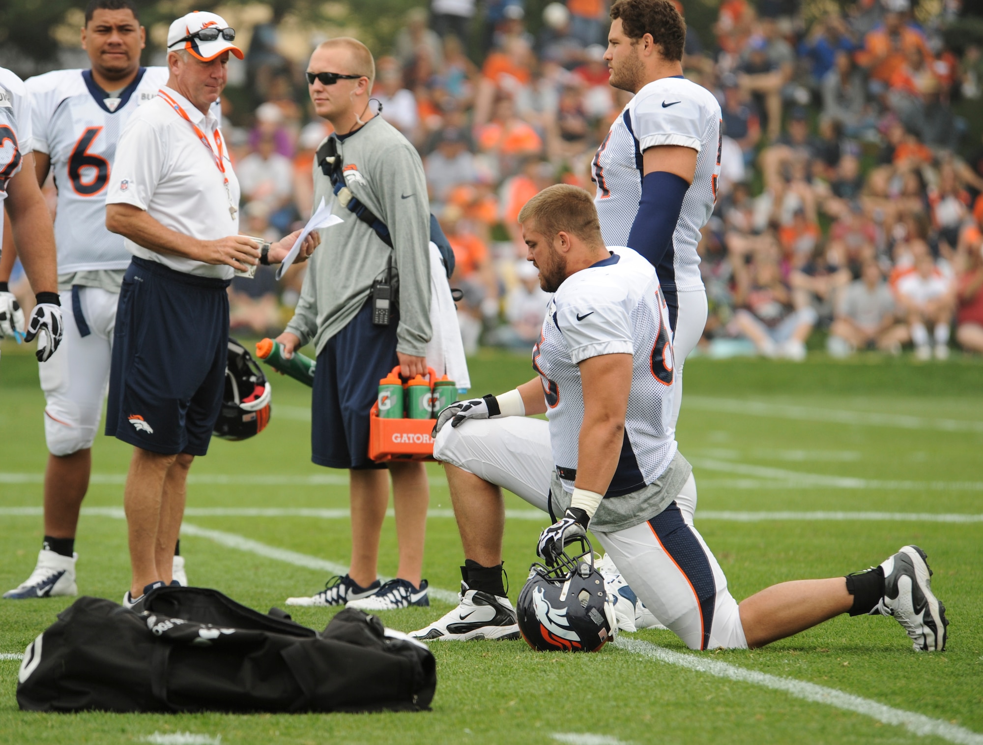 Benjamin Garland, Denver Broncos offensive guard, kneeling, listens to head coach John Fox before a Broncos training camp practice July 29, 2013, at the Broncos training facility, Englewood, Colo.  Garland spent last season on the Broncos practice squad and transitioned from defensive tackle to offensive guard before the Broncos 2013 mini-camp. Garland is also a first lieutenant for the 140th Wing, Colorado Air National Guard, and served his annual commitment during the early part of 2013. (U.S. Air Force photo by Staff Sgt. Christopher Gross/Released)