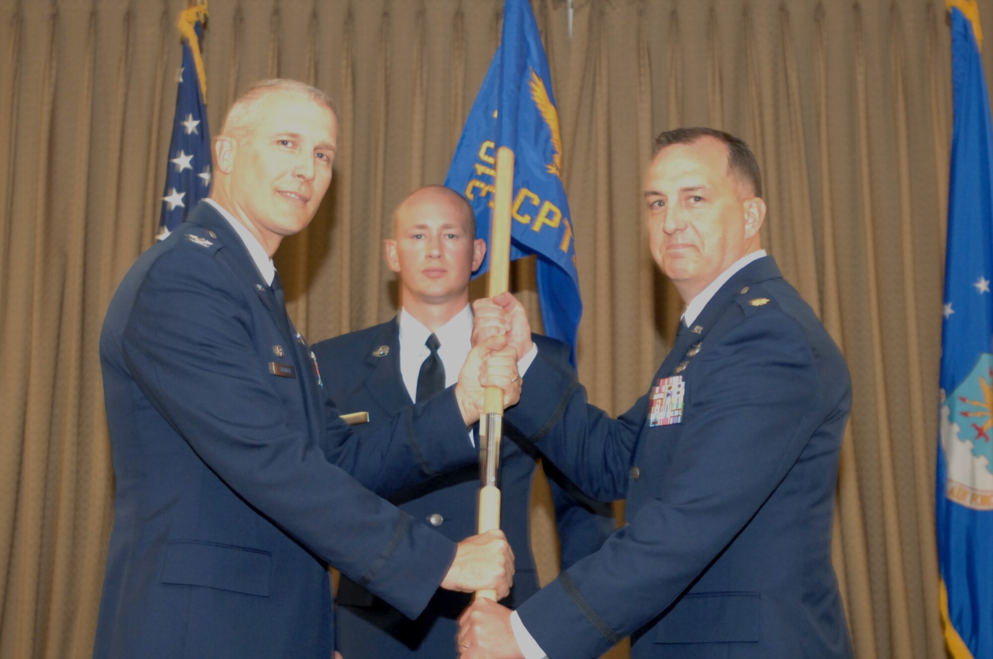 (Left) Col. Paul Bauman, 319th Air Base Wing commander, passes the 319th
Comptroller Squadron guidon to Maj. Frank R. Burks during a
change-of-command ceremony on July 24, 2013, at Grand Forks Air Force Base,
N.D. Burks took over the 319th CPTS from outgoing commander Maj. James E.
Oberg. (U.S. Air Force photo/Staff Sgt. Susan L. Davis)
